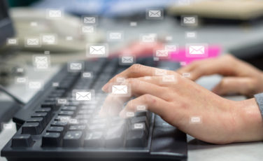 many e mail over the finger pressing the computer keyboard blurred background business technology concept