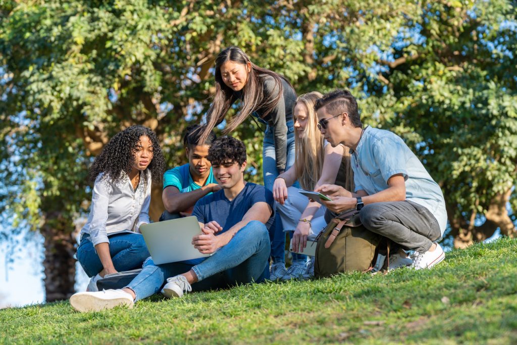 students gathered round a laptop